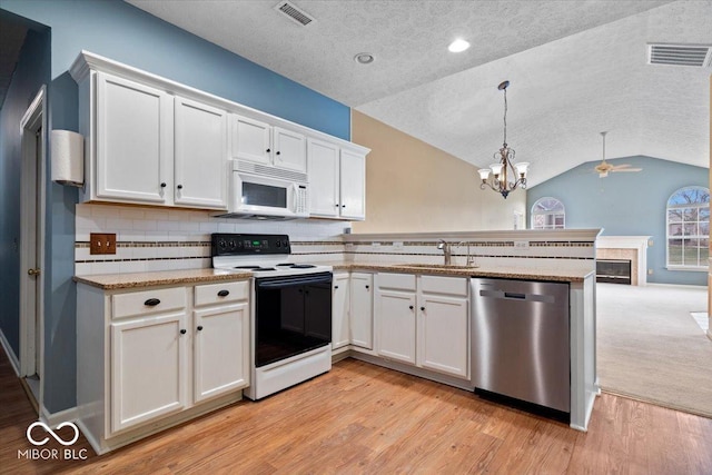 kitchen with sink, pendant lighting, stainless steel dishwasher, range with electric cooktop, and white cabinets