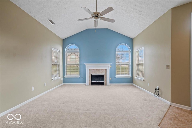 unfurnished living room with a premium fireplace, lofted ceiling, a wealth of natural light, and ceiling fan