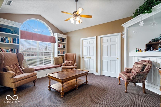 sitting room with dark colored carpet, lofted ceiling, a healthy amount of sunlight, and ceiling fan