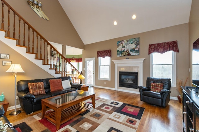 living room featuring wood-type flooring, a healthy amount of sunlight, and high vaulted ceiling