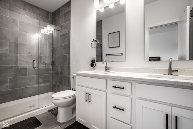 bathroom with vanity, toilet, and a shower with shower door