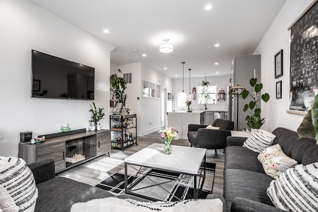 living room with sink and light hardwood / wood-style flooring