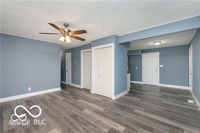 interior space with ceiling fan and dark hardwood / wood-style flooring