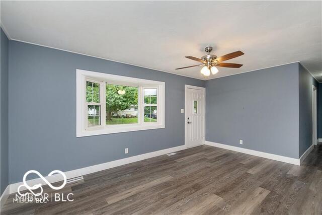 empty room with ceiling fan and dark hardwood / wood-style flooring