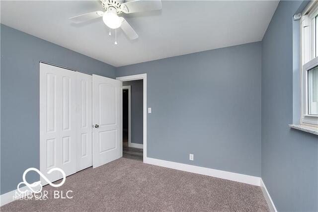 unfurnished bedroom with carpet floors, a closet, and ceiling fan