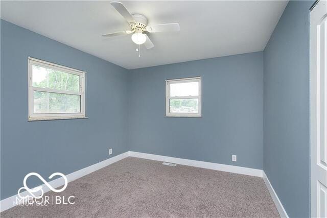 carpeted spare room featuring ceiling fan