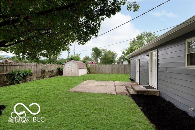 view of yard featuring a storage shed and a patio area