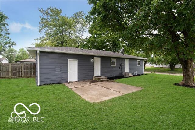 back of house featuring a patio area and a lawn