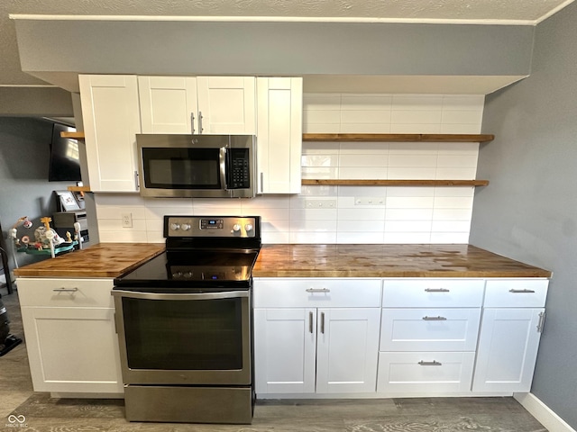 kitchen with wood counters, white cabinetry, tasteful backsplash, dark hardwood / wood-style flooring, and stainless steel appliances