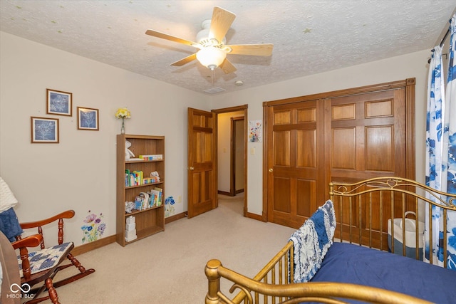 carpeted bedroom with ceiling fan and a textured ceiling