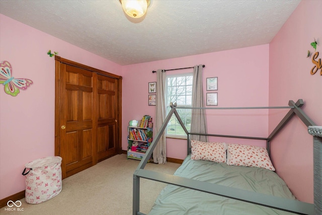 bedroom with light carpet and a textured ceiling