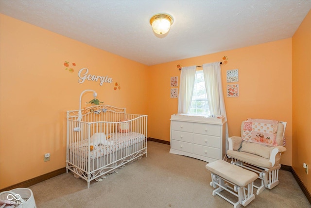 bedroom with a crib, carpet flooring, and a textured ceiling