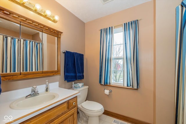 bathroom featuring vanity, a textured ceiling, and toilet