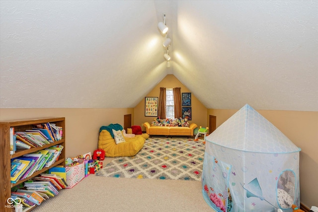 game room featuring rail lighting, carpet, lofted ceiling, and a textured ceiling