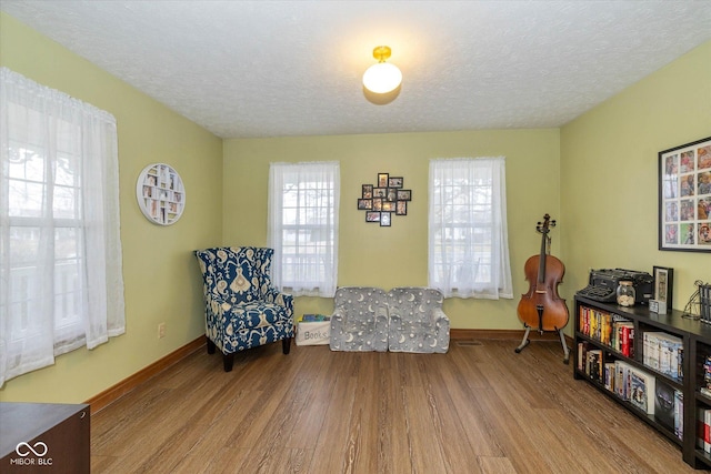 living area with a textured ceiling and light hardwood / wood-style flooring