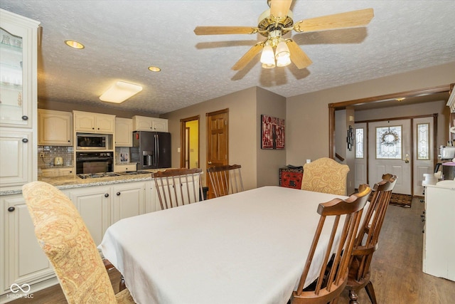 dining area featuring dark hardwood / wood-style flooring, ceiling fan, and a textured ceiling