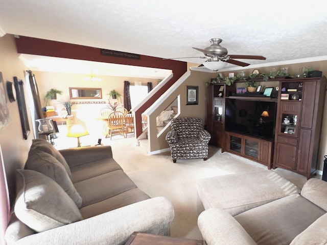 carpeted living room with crown molding, ceiling fan, and a textured ceiling