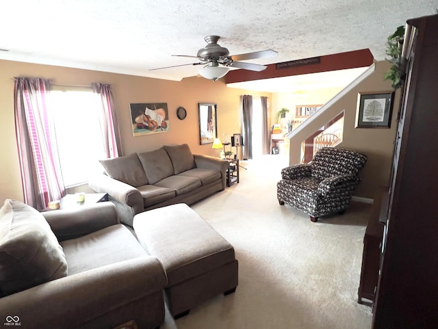 living room with ceiling fan, light colored carpet, and a textured ceiling