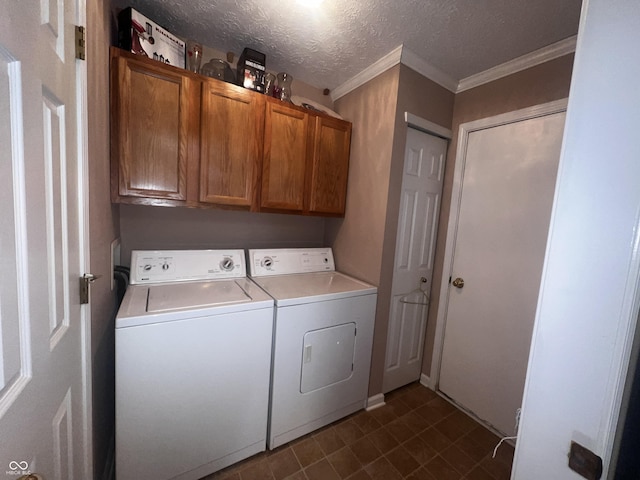 laundry area with crown molding, a textured ceiling, cabinets, and washing machine and clothes dryer