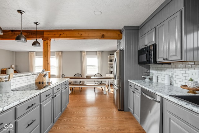 kitchen with gray cabinetry, decorative light fixtures, light wood-type flooring, decorative backsplash, and black appliances