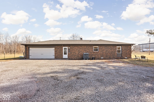 rear view of house featuring cooling unit and a garage