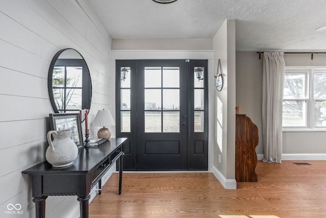 foyer entrance featuring light hardwood / wood-style floors and a textured ceiling