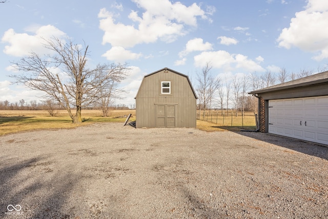 view of outdoor structure with a garage and a rural view