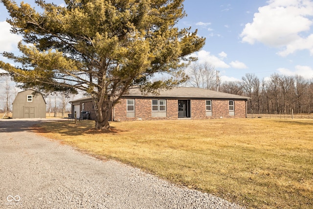 ranch-style house with an outbuilding and a front lawn