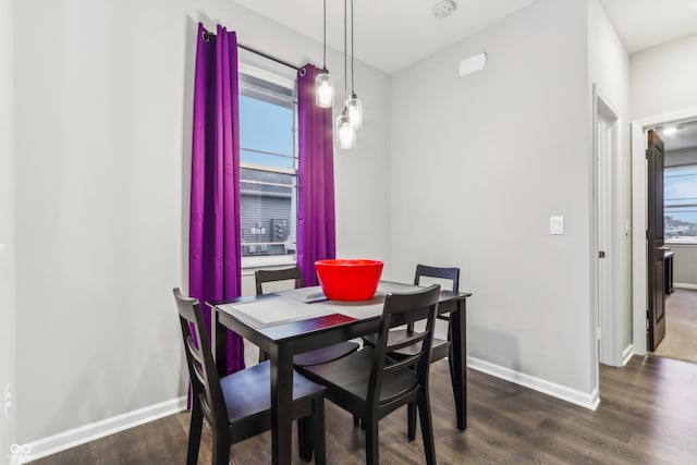 dining space with plenty of natural light and dark hardwood / wood-style flooring