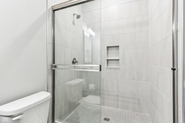 bathroom featuring walk in shower and toilet