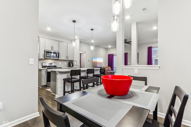 dining area with dark hardwood / wood-style flooring and ceiling fan