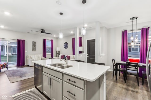 kitchen with sink, a center island with sink, dark hardwood / wood-style flooring, decorative light fixtures, and stainless steel dishwasher