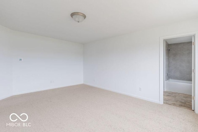 unfurnished room with baseboards and light colored carpet