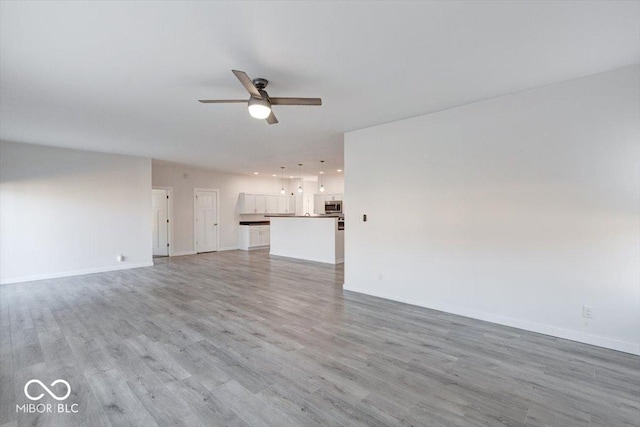 unfurnished living room with light hardwood / wood-style floors and ceiling fan