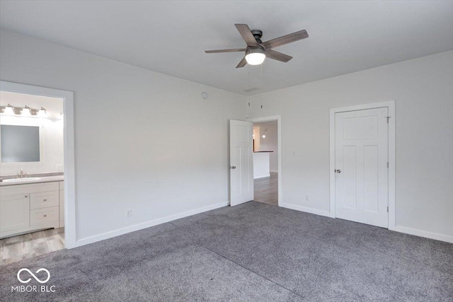 unfurnished bedroom with sink, ensuite bath, carpet floors, and ceiling fan