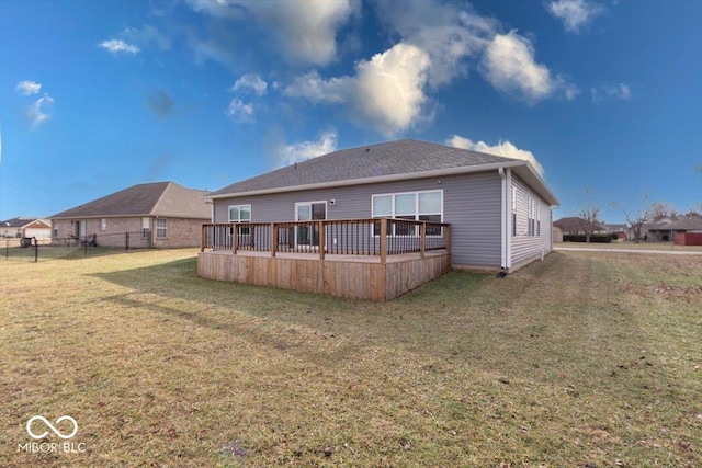 back of house featuring a wooden deck and a lawn