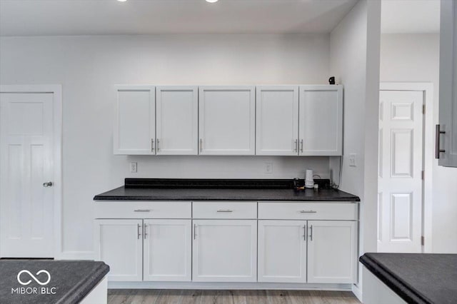 kitchen with light hardwood / wood-style floors and white cabinets