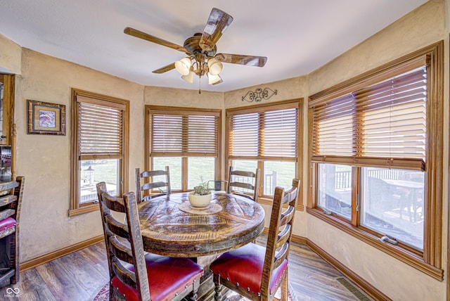 dining space featuring ceiling fan and dark wood-type flooring