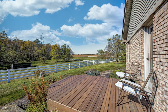 wooden deck featuring a rural view and a lawn