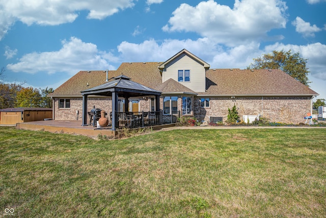 back of property with a hot tub, a patio area, a gazebo, and a lawn