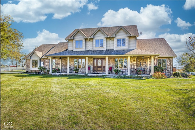 view of front of house featuring covered porch, roof with shingles, fence, and a front yard