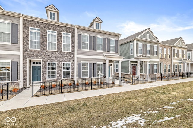 townhome / multi-family property featuring a front yard and fence