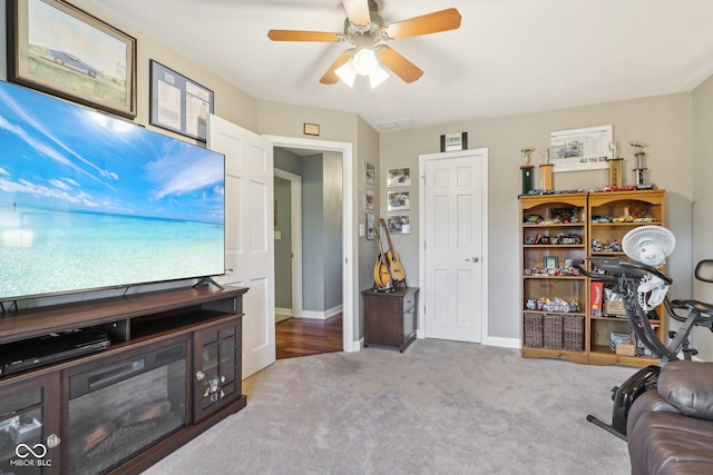 carpeted living room with ceiling fan