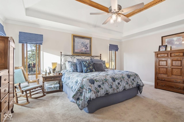 carpeted bedroom featuring a raised ceiling, crown molding, and ceiling fan