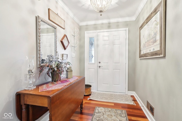 entryway with wood-type flooring, a chandelier, and crown molding