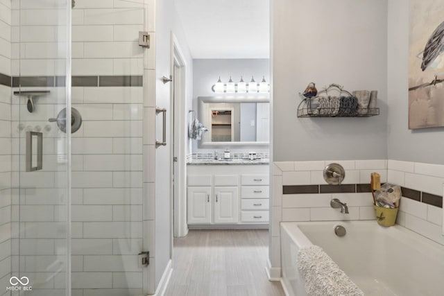 bathroom with vanity, hardwood / wood-style floors, and independent shower and bath