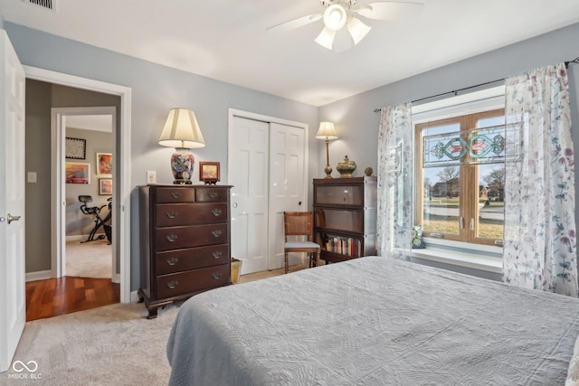 carpeted bedroom with ceiling fan and a closet