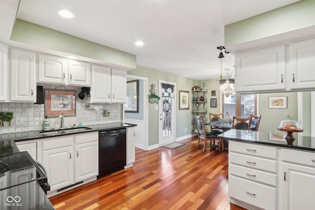 kitchen with pendant lighting, sink, dishwasher, white cabinetry, and decorative backsplash