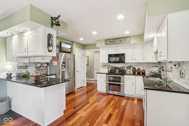 kitchen with white cabinetry, stainless steel appliances, sink, and hardwood / wood-style flooring