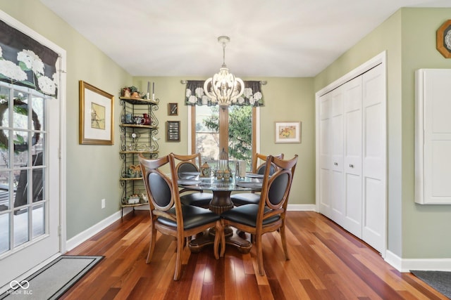 dining area with dark hardwood / wood-style floors and a notable chandelier